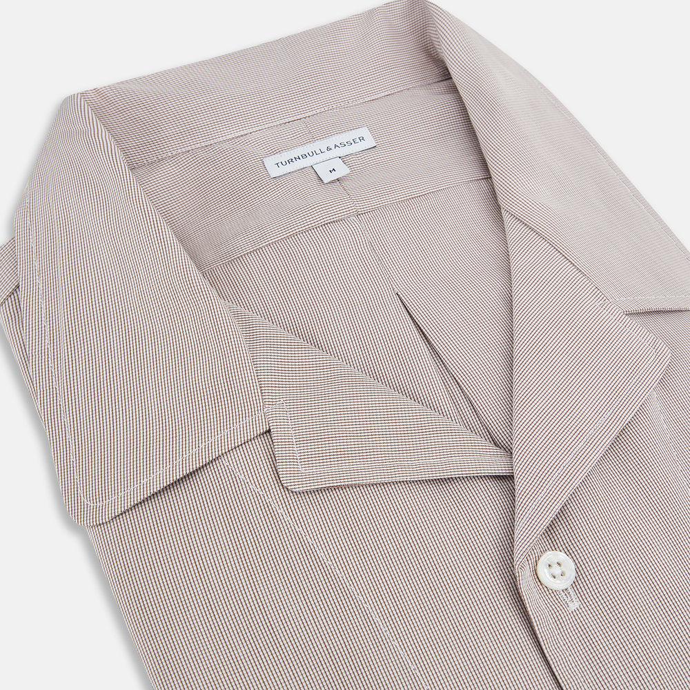 The Turnbull & Asser Brown Micro Check Quarzo Nightshirt is a long-sleeve shirt dress inspired by classic sleepwear, featuring a collar, chest pocket, upper front buttons, and a subtle micro check pattern on a white background.