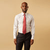 View 1 of product A man stands against a beige background, facing forward with a neutral expression and arms relaxed, wearing the Turnbull & Asser Red Multi Check Regular Fit Mayfair Shirt.