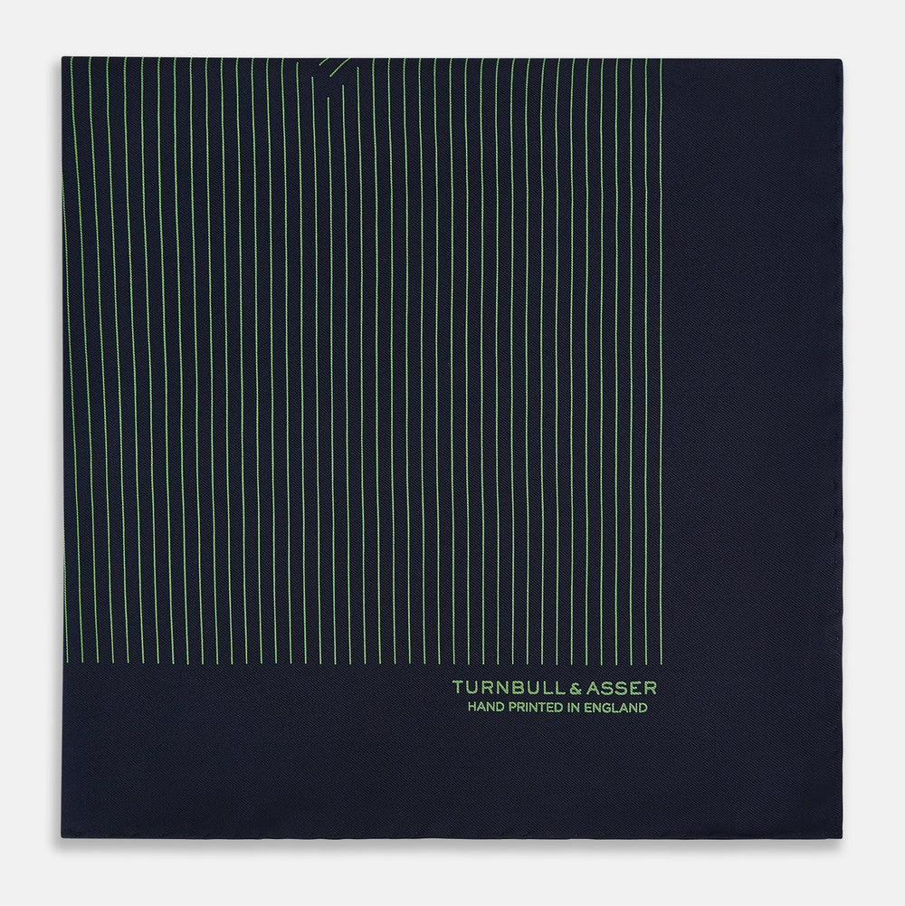The Navy and Fern Green Stripe Silk Pocket Square by Turnbull & Asser features green vertical and diagonal stripes, hand-rolled edges, and "TURNBULL & ASSER HAND PRINTED IN ENGLAND" printed in one corner.