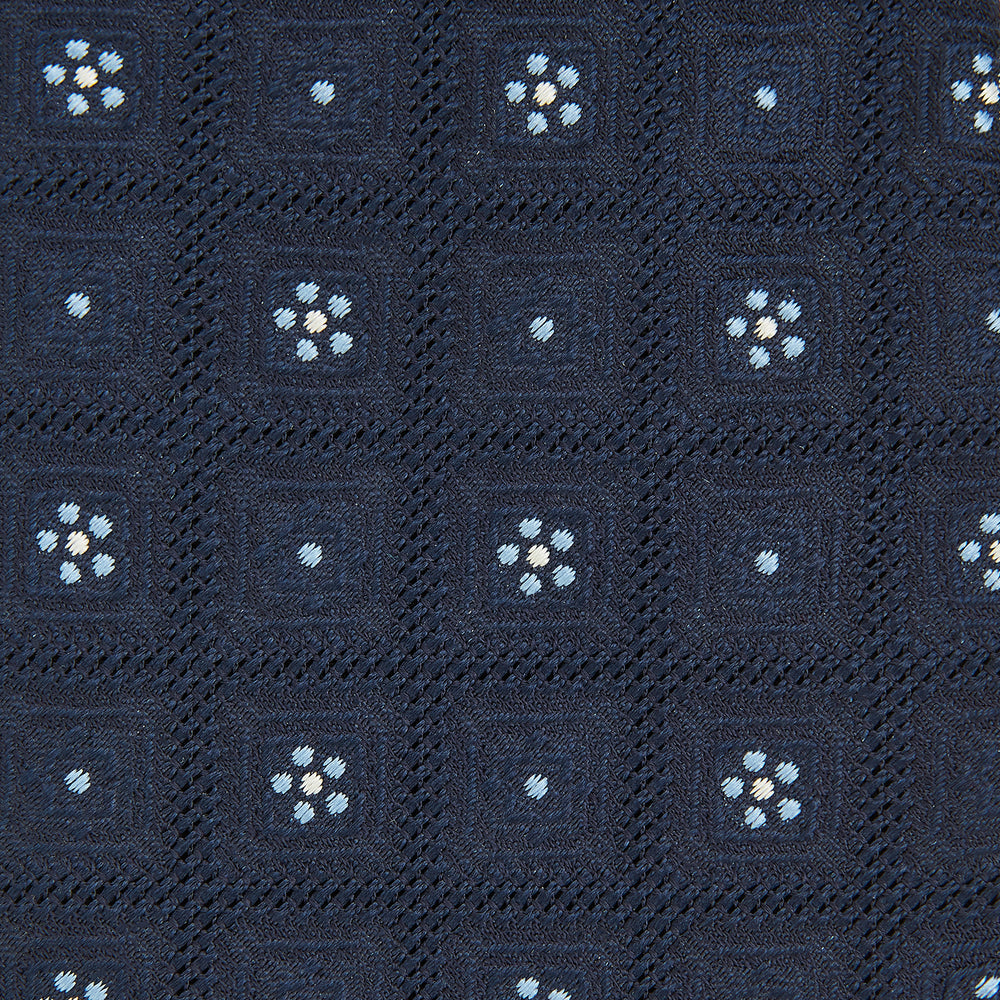 The Turnbull & Asser Jacquard Silk Circle Tie showcases a textured navy blue design with small white and light blue floral motifs—an essential accessory for refined attire.