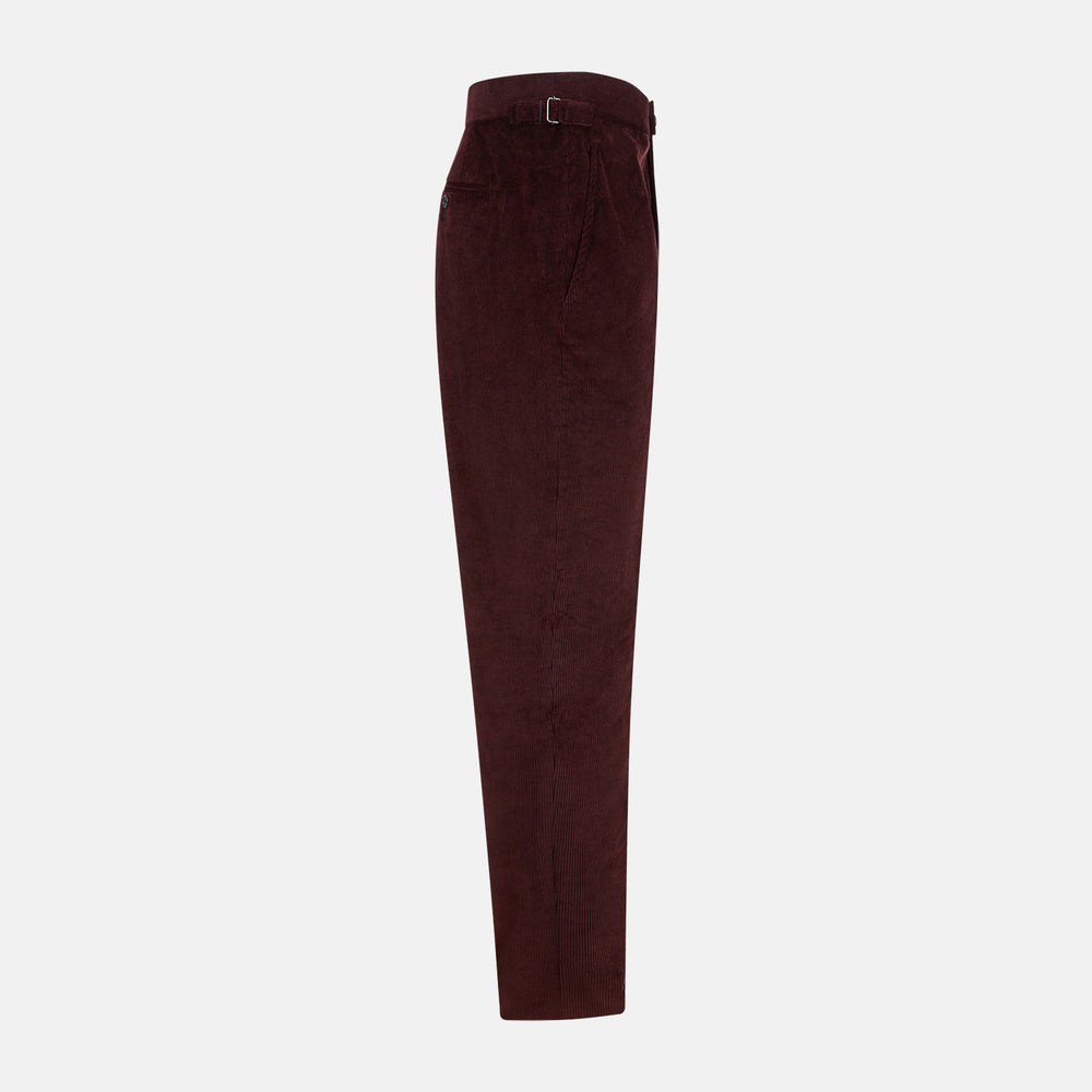 The Turnbull & Asser Burgundy Corduroy Henry Trousers feature a straight-leg cut, button and zip closure, and adjustable side tabs—perfect for refined formalwear—shown here on a plain white background.