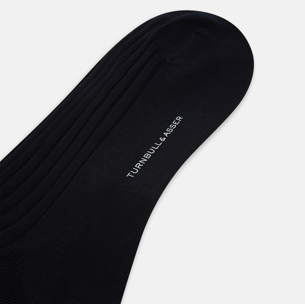 A single Midnight Blue Long Sock by Turnbull & Asser is shown on a white background, showcasing a ribbed texture and a fitted design that extends from the foot to the top of the calf.