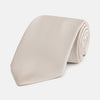View 1 of product The Turnbull & Asser HORIZONTAL TWILL VELLUM TIE, a light beige silk necktie with a subtle ribbed texture, is shown rolled up on a white background—an essential finishing touch for smart attire.