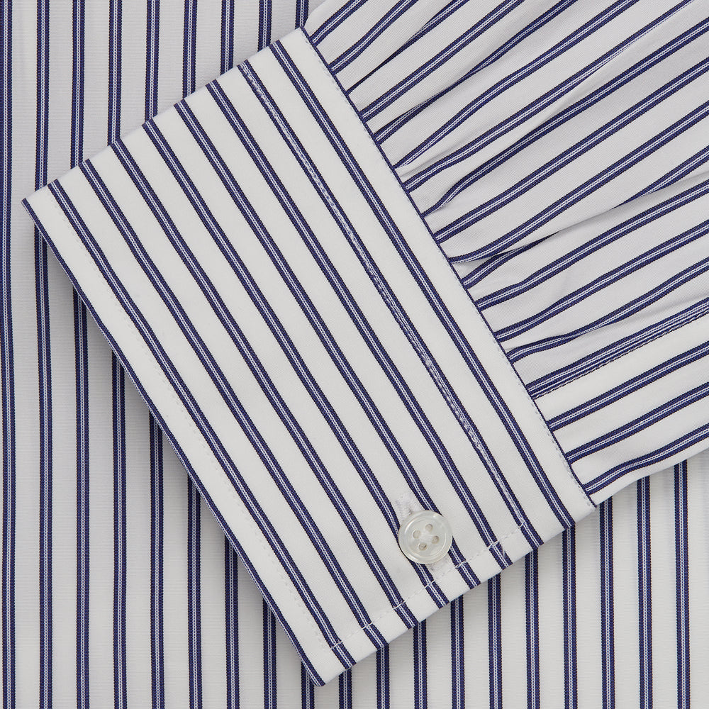 The Turnbull & Asser Navy Stripe Weekend Fit Shirt features a Derby collar, vertical navy and white stripes, 1-button cuffs, a chest pocket, and a regular fit, shown laid flat against a white background.