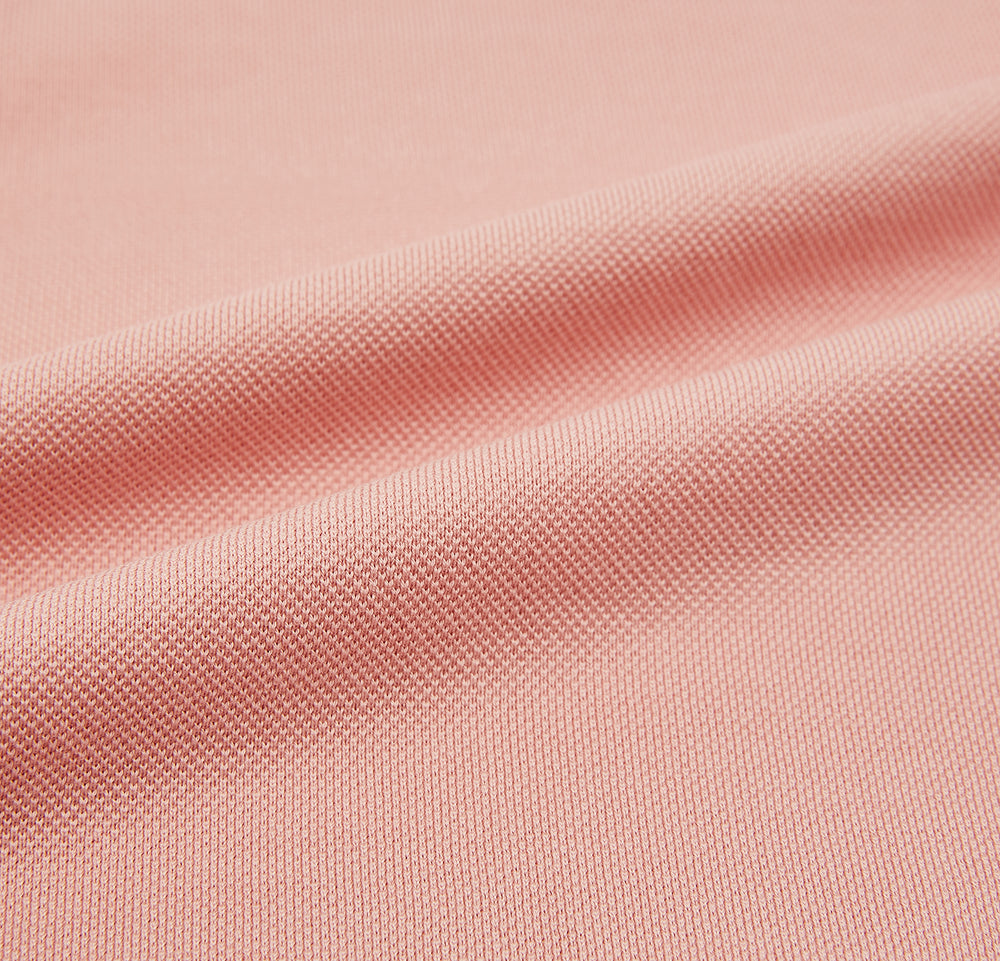 The Orange Polo Shirt by Turnbull & Asser features short sleeves, a collar, three-button placket, and a small buttoned chest pocket in soft cotton jersey—timeless men's style laid flat on a white background.