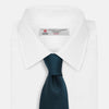 View 2 of product The Turnbull & Asser Navy Houndstooth Forest Green Tie is shown rolled up, featuring a subtle houndstooth pattern against a plain white background.