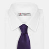 View 2 of product The HOUNDSTOOTH NAVY PLUM TIE by Turnbull & Asser, featuring a textured pattern, is showcased rolled up against a plain white background—an essential accessory.
