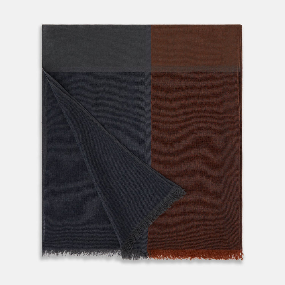 The Turnbull & Asser Brown and Navy Cashmere Scarf features a long, rectangular shape, color block design, soft texture, and lightly frayed edges, elegantly folded on a plain white background.