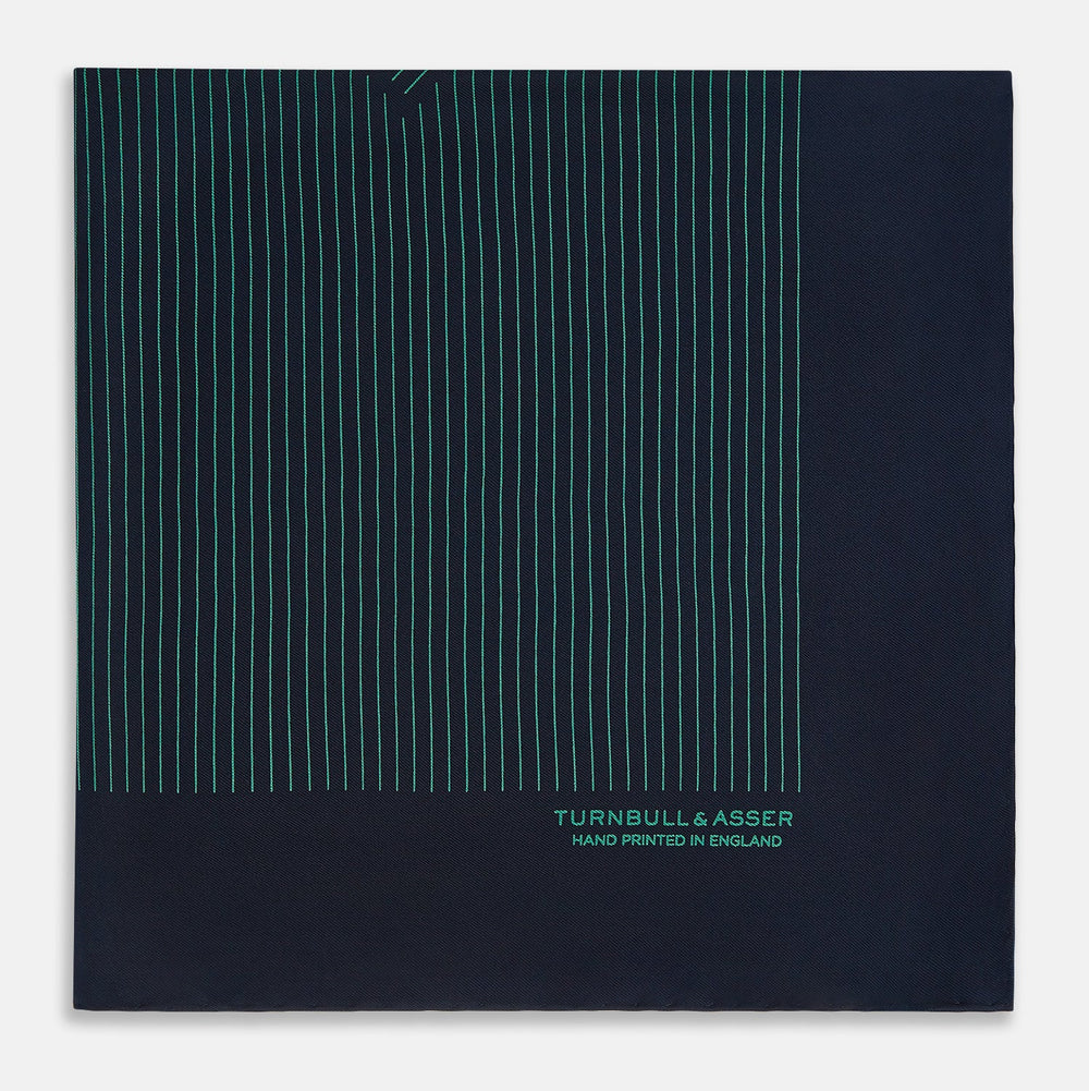 A Navy and Petrol Green Stripe Silk Pocket Square by Turnbull & Asser, featuring thin petrol green stripes and "Turnbull & Asser Hand Printed in England" in the bottom right corner. One corner is folded to display hand-rolled edges.