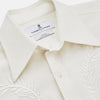 View 2 of product The Cream Silk Long Point Embroidered Eamon Shirt by Turnbull & Asser features long sleeves, a pointed collar, and delicate botanical embroidery. Its buttoned cuffs and tailored fit make it an elegant partywear choice.
