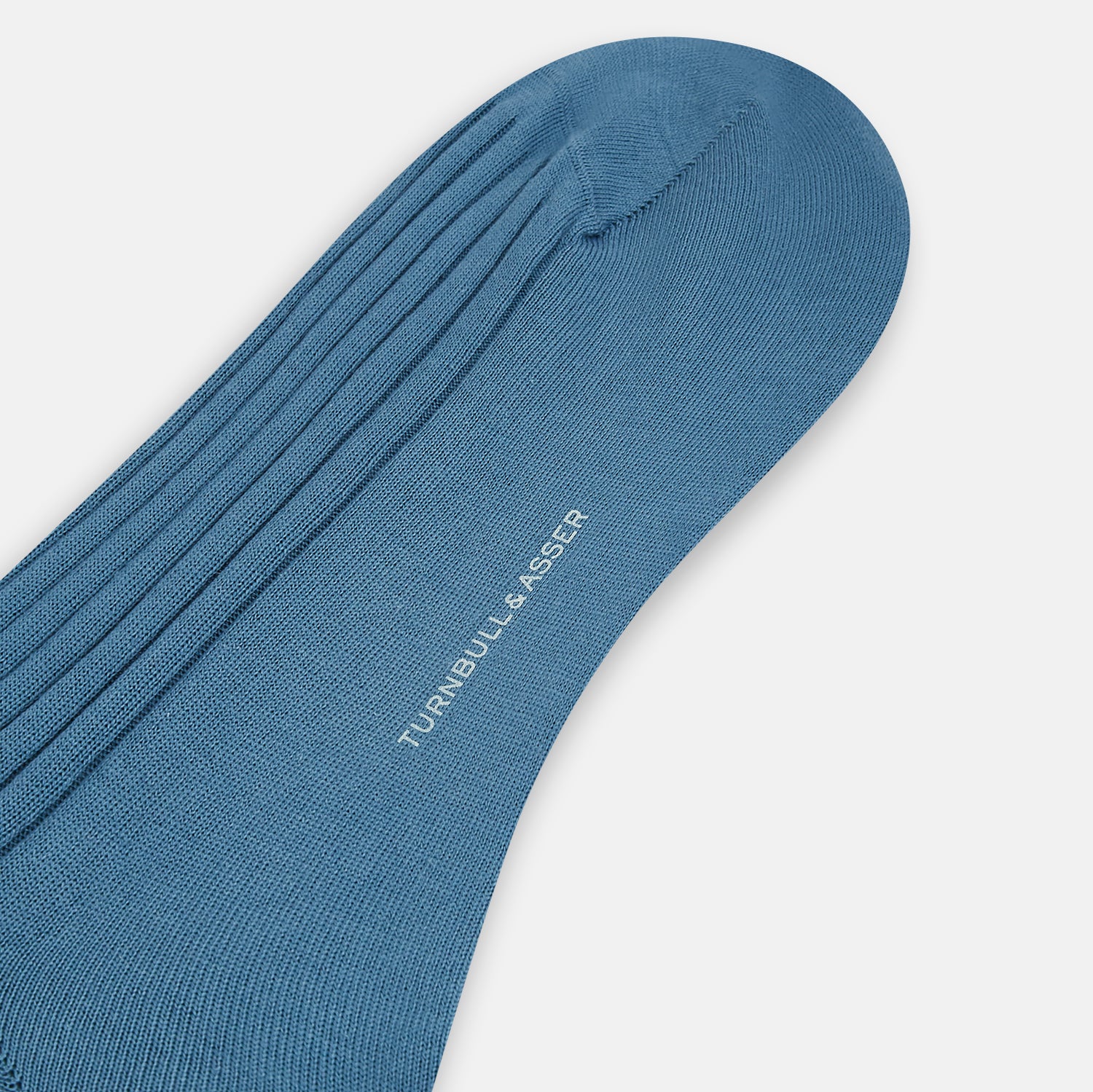 View 3 of product The Azzurro Organic Cotton Mid-Length Sock by Turnbull & Asser, featuring a ribbed texture in blue, is displayed against a plain white background.