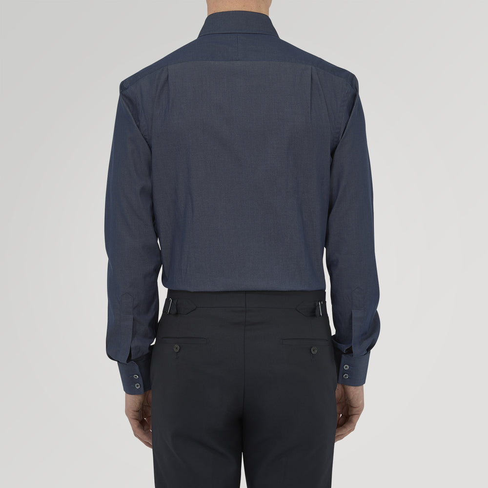 A neatly folded Turnbull & Asser Dark Blue Denim-Cashmere Shirt with a T&A collar and double cuffs, featuring black buttons, shown on a white background. The label inside the collar highlights its smart finish and refined style.
