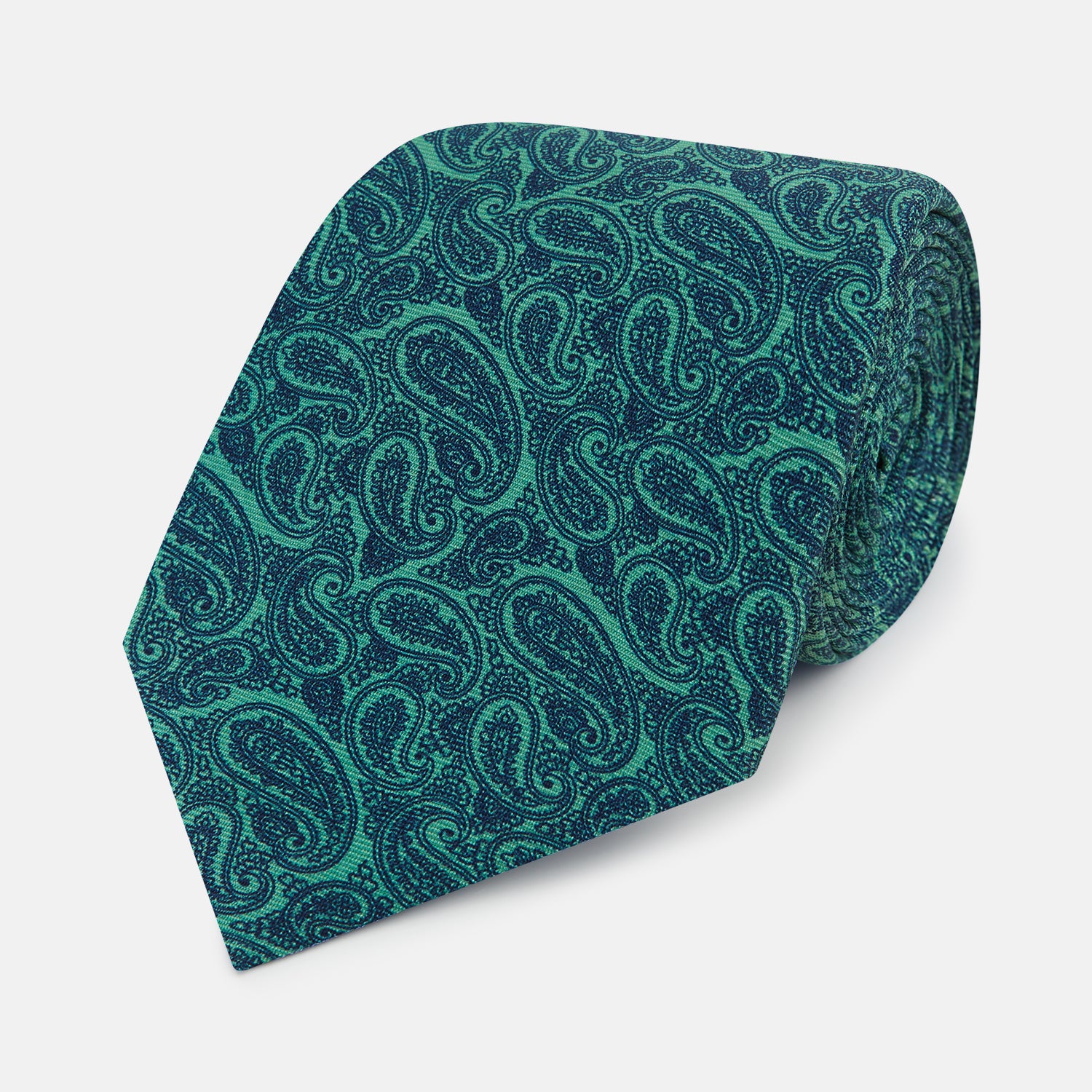 View 1 of product The Turnbull & Asser Kelly Green Paisley Silk Tie is shown rolled on a plain white background, featuring an intricate paisley pattern in rich green tones.