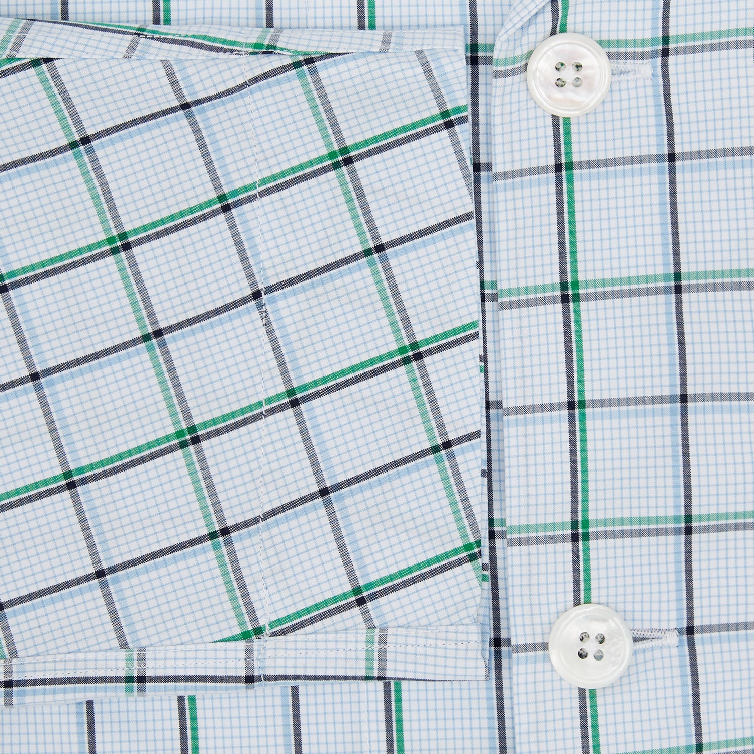 View 4 of product The Turnbull & Asser Green and Blue Check Pyjama Shirt features long sleeves and a button-up design on a white base, offering elegant loungewear style. Shown laid flat against a white background.