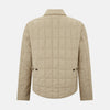 View 3 of product The Battersea Sand Quilted Jacket by Turnbull & Asser is a light beige men's jacket with a front zipper, pointed collar, zippered side pockets, chest pocket, and buttoned cuffs, shown on a plain white background.