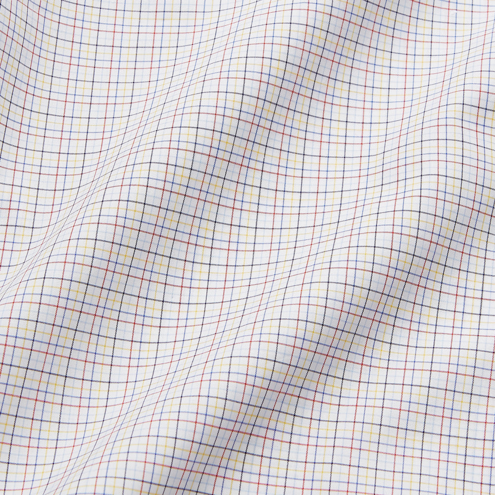 A man stands against a beige background, facing forward with a neutral expression and arms relaxed, wearing the Turnbull & Asser Red Multi Check Regular Fit Mayfair Shirt.