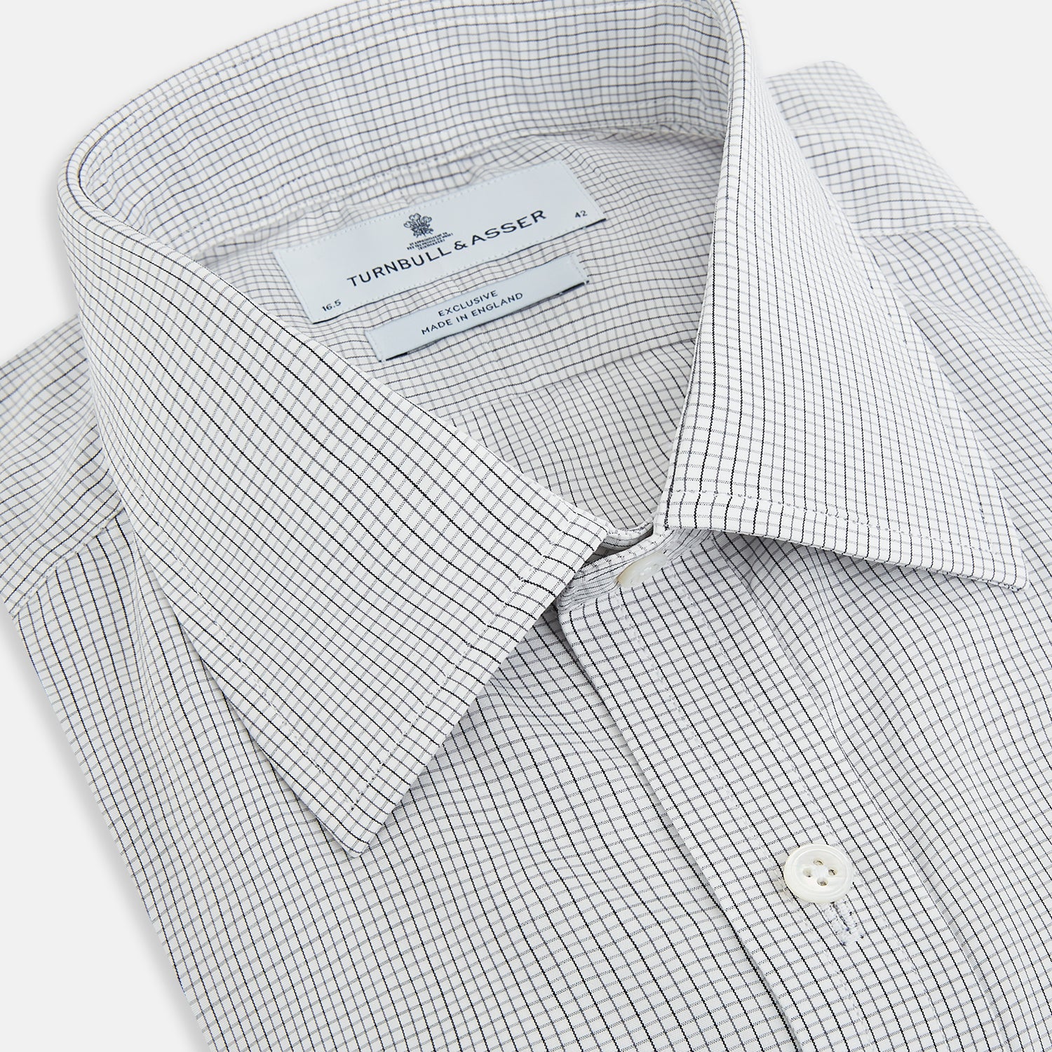 View 2 of product A tailored-fit Turnbull & Asser Mayfair Shirt in midnight blue with a grid check pattern, spread collar, and buttoned cuffs, crafted from premium Italian cotton and laid flat on a white background.