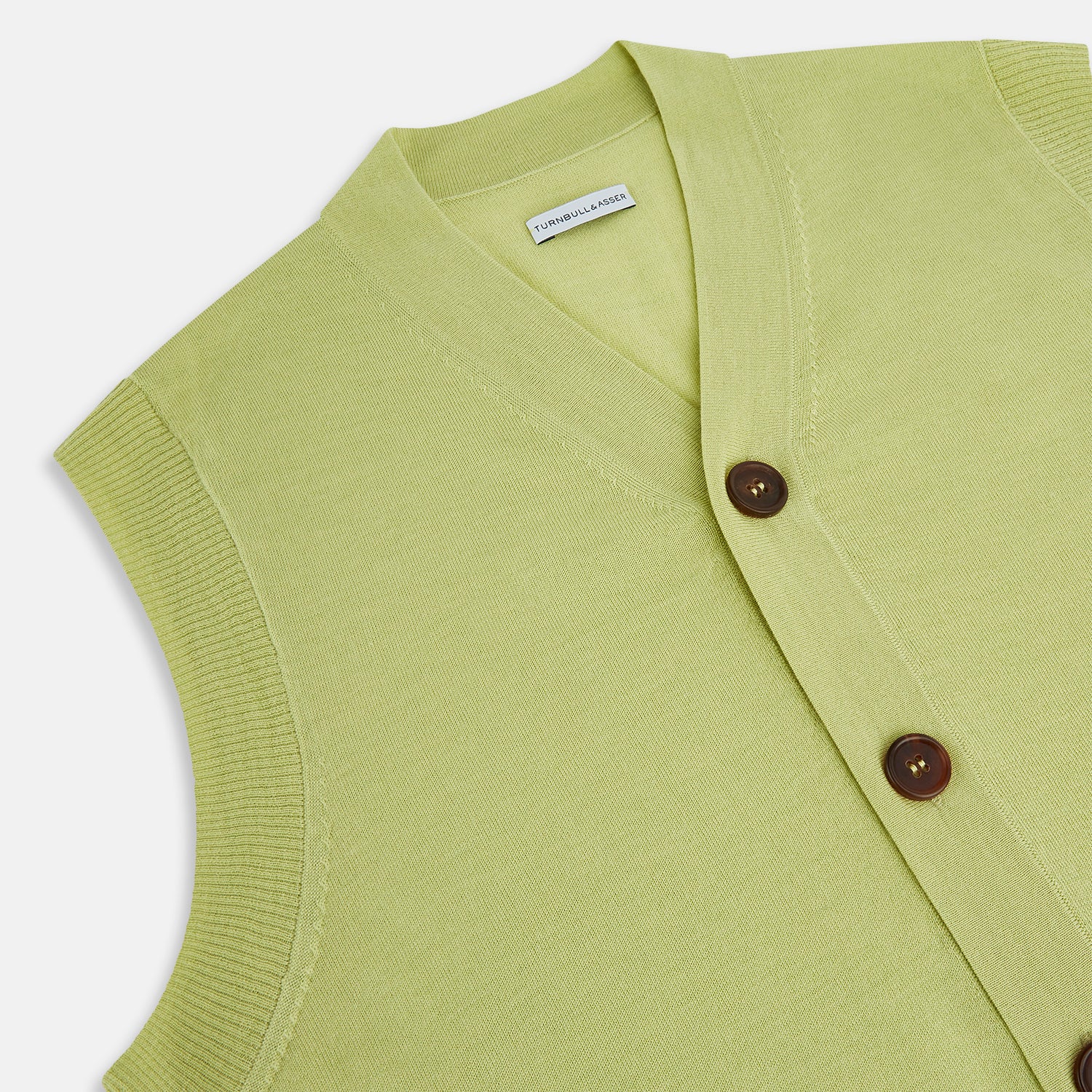 View 2 of product The Melon Green Fine Merino V-Neck Sleeveless Cardigan by Turnbull & Asser features a ribbed collar, five dark brown buttons, and two front pockets—adding sophisticated style to any ensemble, shown against a plain white background.