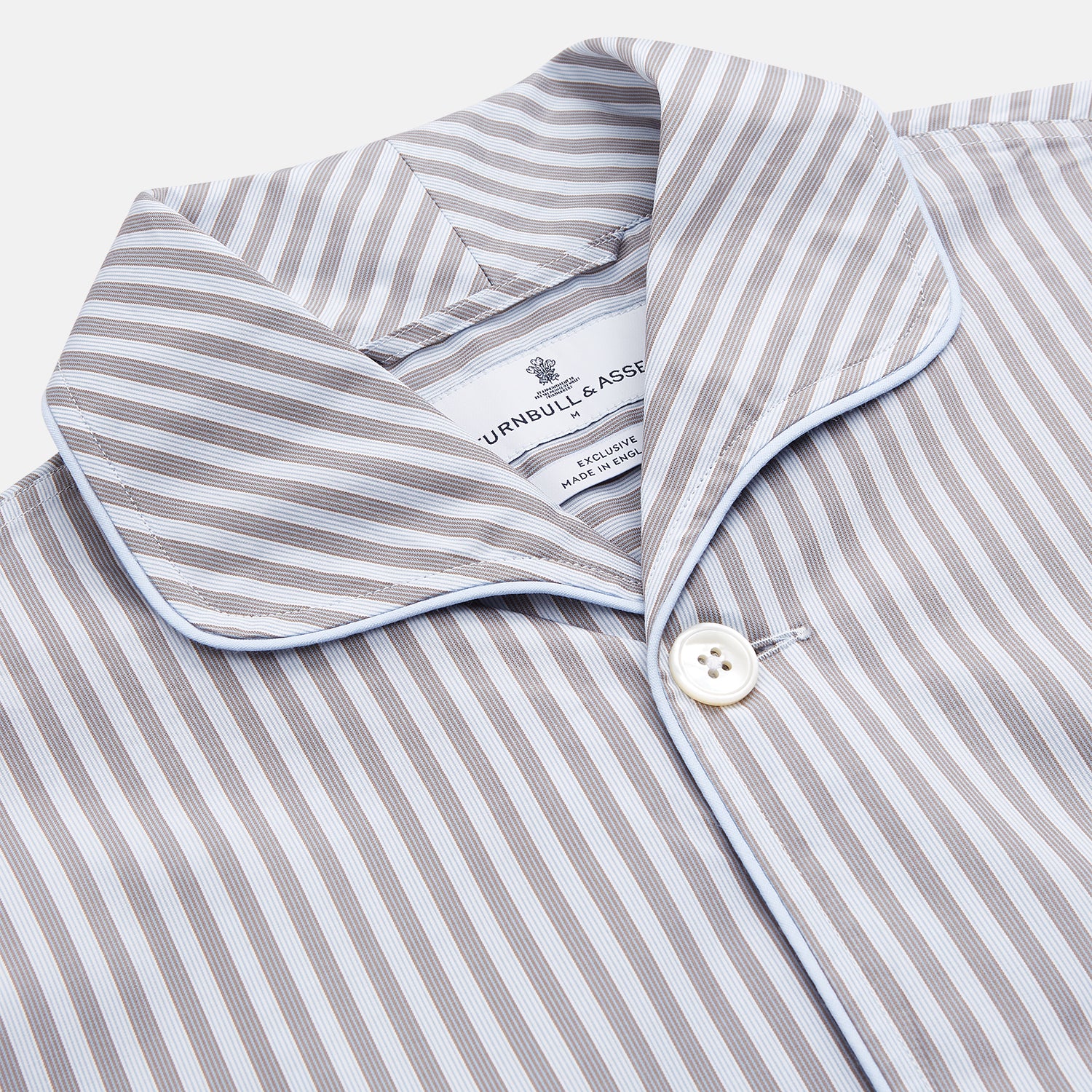View 4 of product The Turnbull & Asser Pale Blue Multi Stripe Cotton Quin Pyjamas, featuring a long-sleeve button-up top and matching adjustable tie-waist pants, are neatly arranged on a white background.