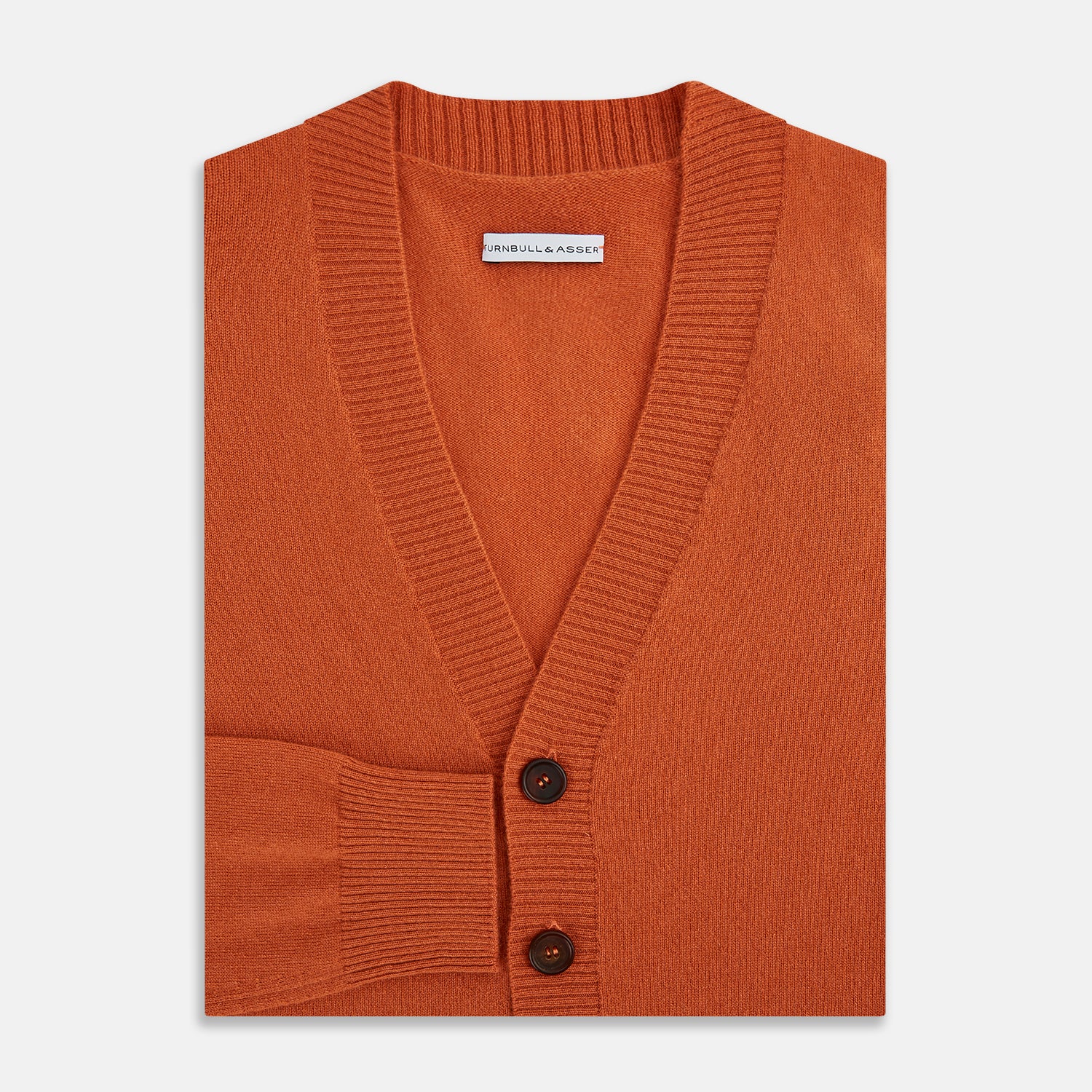 View 4 of product The Orange Cashmere Cardigan by Turnbull & Asser showcases vibrant burnt orange, a V-neck, dark buttons, ribbed cuffs and hem, long sleeves, and two front pockets. Part of the knitwear collection; displayed on a white background.