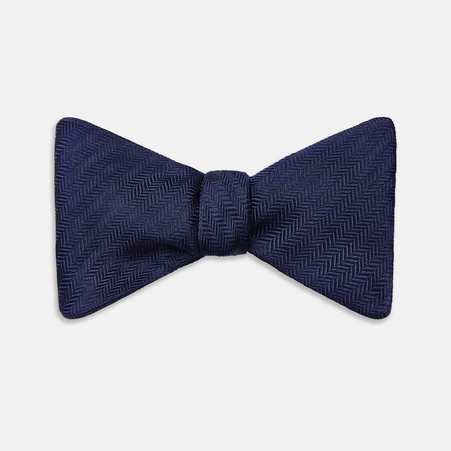 View 1 of product The Turnbull & Asser HERRINGBONE NAVY BOW TIE features a subtle herringbone pattern in navy blue, shown against a plain white background—the perfect accessory to elevate any smart look.