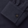 View 6 of product A man stands against a beige background wearing the Turnbull & Asser Navy Weekend Fit Cotton & Wool Shirt with a Derby collar and 1 button cuffs, paired with brown pants and black shoes, looking to the side with a neutral expression.