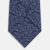 View 3 of product The Turnbull & Asser Navy Paisley Silk Tie features a detailed light purple pattern and is shown rolled up against a plain white background.