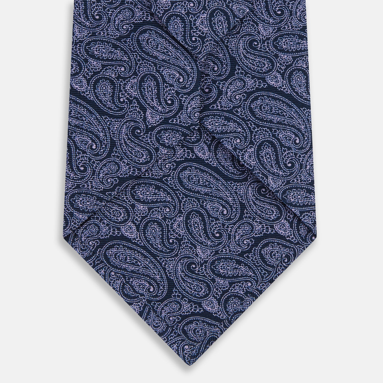 View 3 of product The Turnbull & Asser Navy Paisley Silk Tie features a detailed light purple pattern and is shown rolled up against a plain white background.