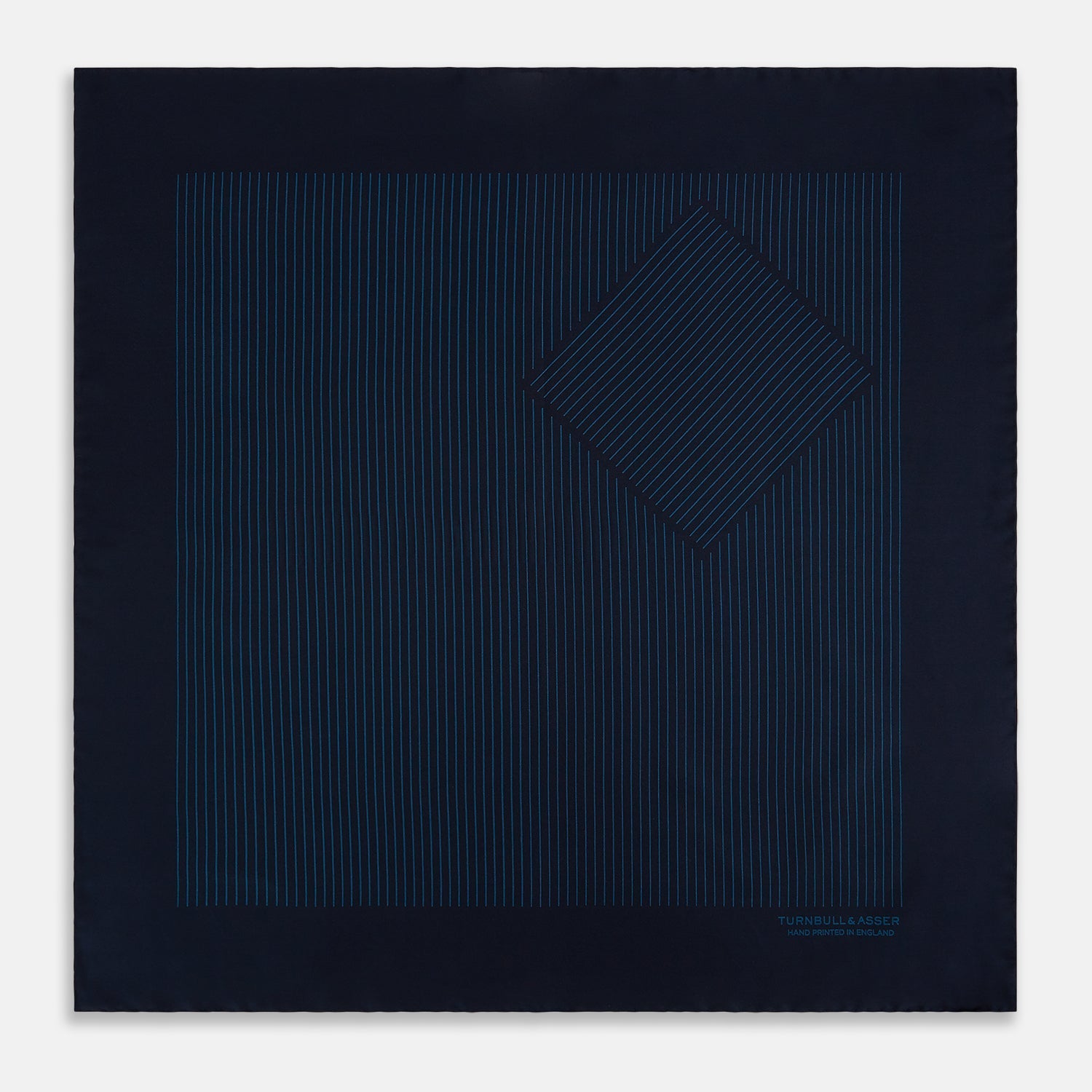 View 3 of product The Navy and Blue Stripe Silk Pocket Square by Turnbull & Asser features vertical blue pinstripes, is crafted from silk with hand-rolled edges, and is finished with the brand's logo printed in blue at the lower right corner.