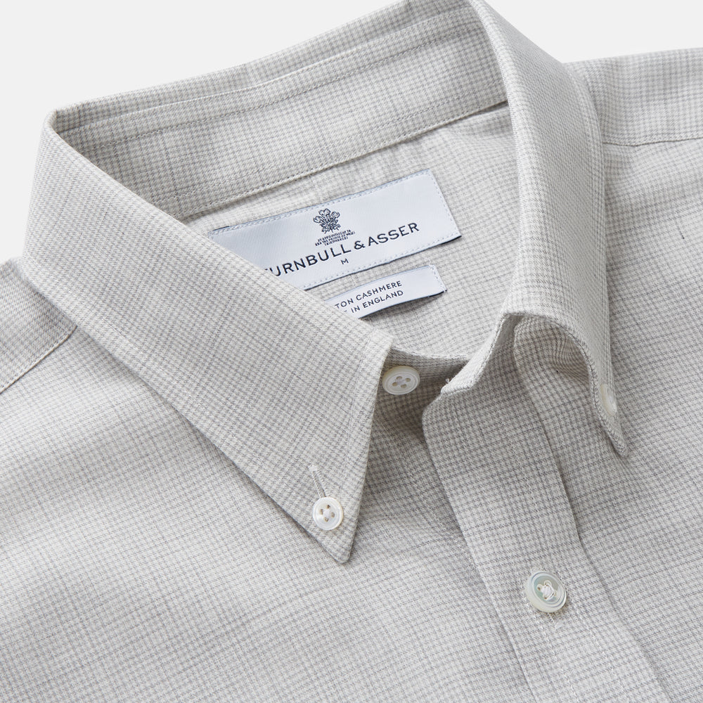 A Grey Fine Check Cotton Blend Weekend Fit Suffolk Shirt by Turnbull & Asser with long sleeves, a collar, and single chest pocket is laid flat on a white background.