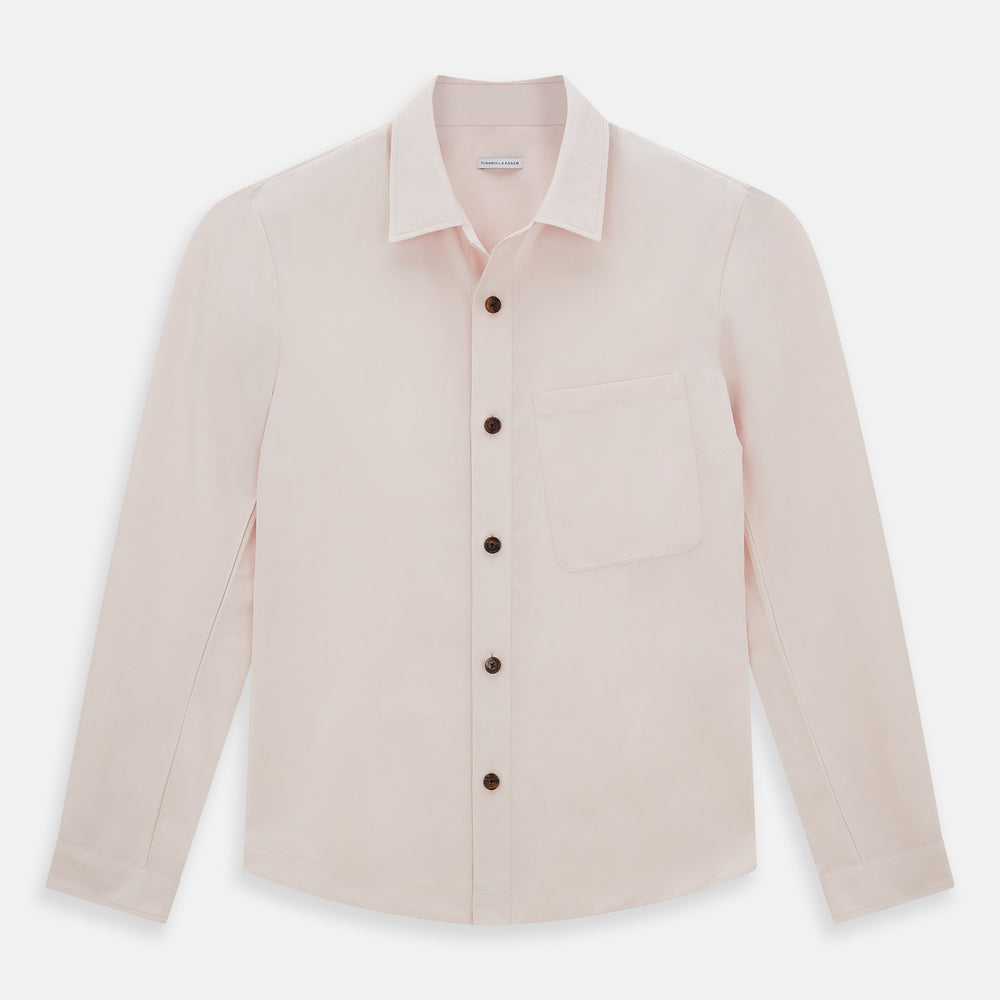 The Turnbull & Asser Pale Pink Hyde Overshirt is a long-sleeve, sanforised cotton button-up with a left chest pocket and dark buttons, shown laid flat on a white background.