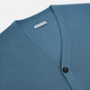 View 2 of product The Turnbull & Asser Pale Blue Fine Merino V-Neck Cardigan features long sleeves and five black buttons, showcased on a plain white background.