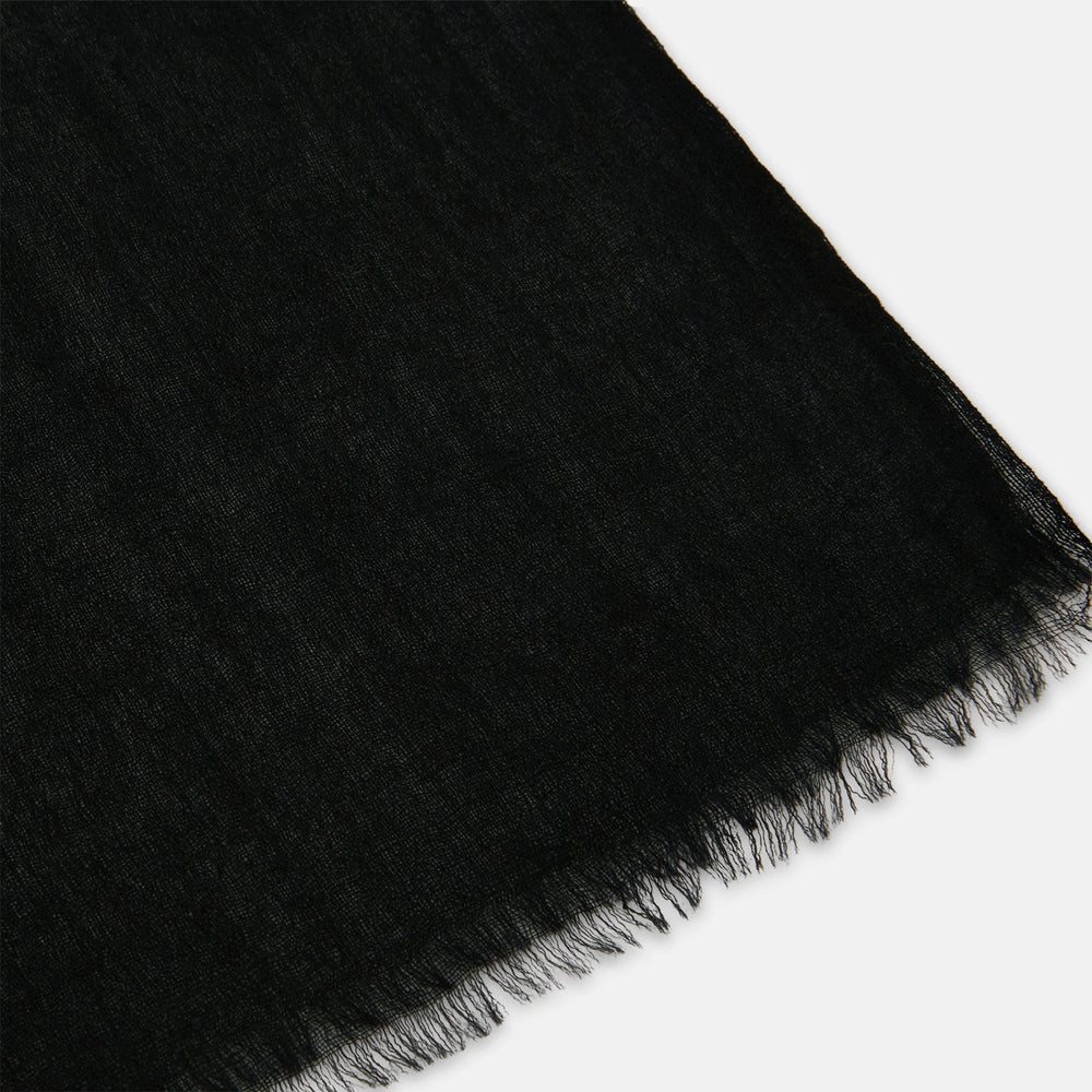 The Turnbull & Asser Charcoal Melange Cashmere Scarf features a smooth texture, subtle frayed edges, and a loosely knotted style, elegantly displayed on a white background—an ideal luxury accessory for any season.