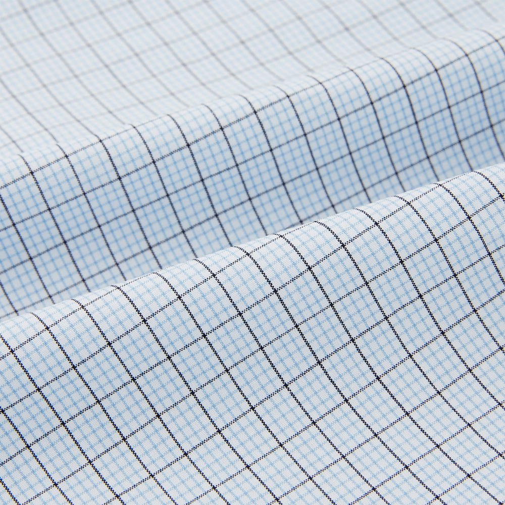 The Turnbull & Asser Blue Graph Check Pyjama Shirt features long sleeves, a collar, and a small check pattern in light blue—ideal as elegant loungewear.