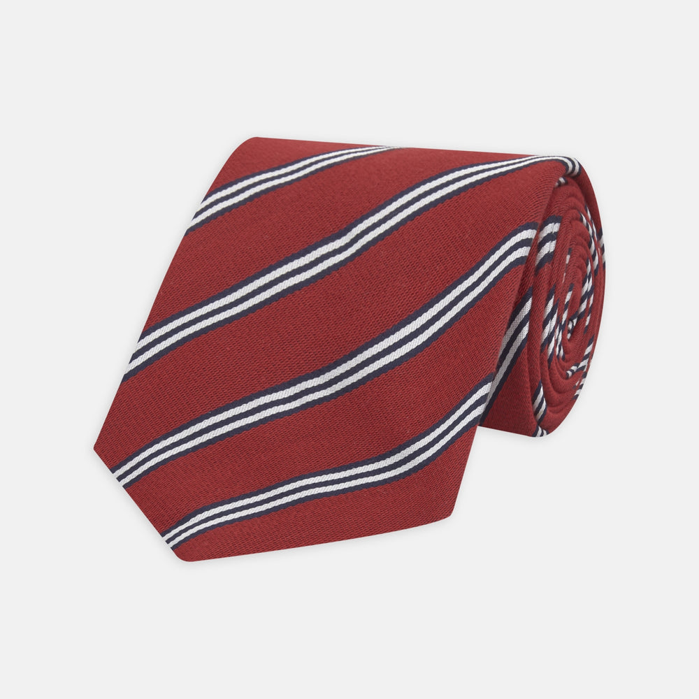 The Turnbull & Asser GGT92000 3042 48 OS is a rolled-up red cotton silk stripe tie with diagonal white and navy blue stripes, displayed on a plain white background.