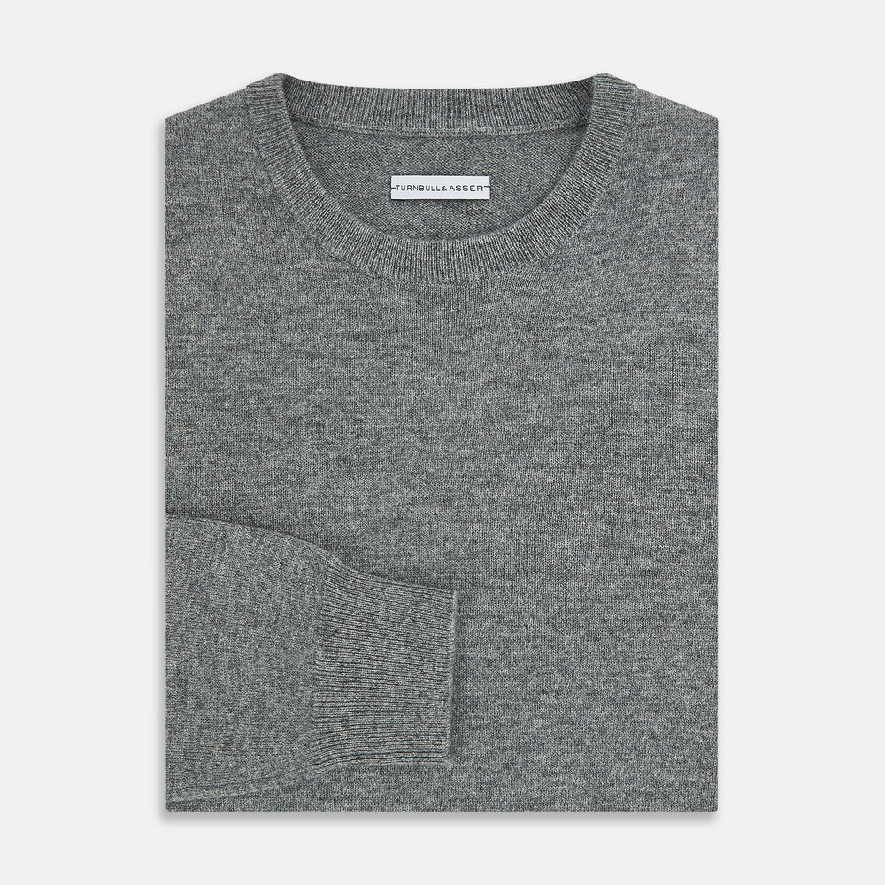 The Turnbull & Asser Grey Melange Cashmere Round Neck Jumper for men features a classic crewneck design with ribbed cuffs, hem, and neckline, displayed against a white background.