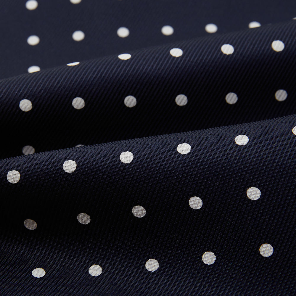 The White Dot and Navy Silk Cravat by Turnbull & Asser features evenly spaced white polka dots on navy silk—a classic accessory ideal for adding British elegance to any look.