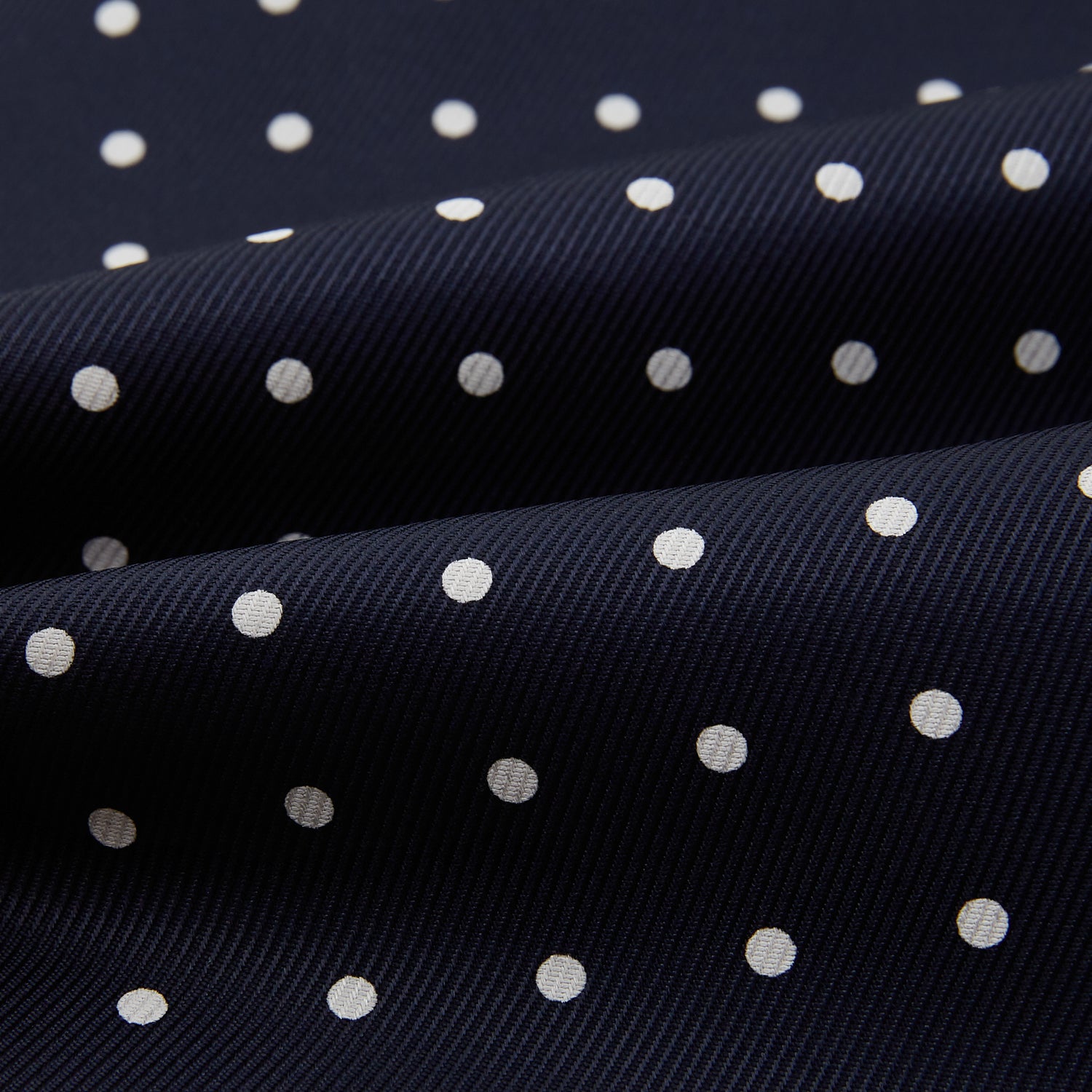 View 4 of product The White Dot and Navy Silk Cravat by Turnbull & Asser features evenly spaced white polka dots on navy silk—a classic accessory ideal for adding British elegance to any look.