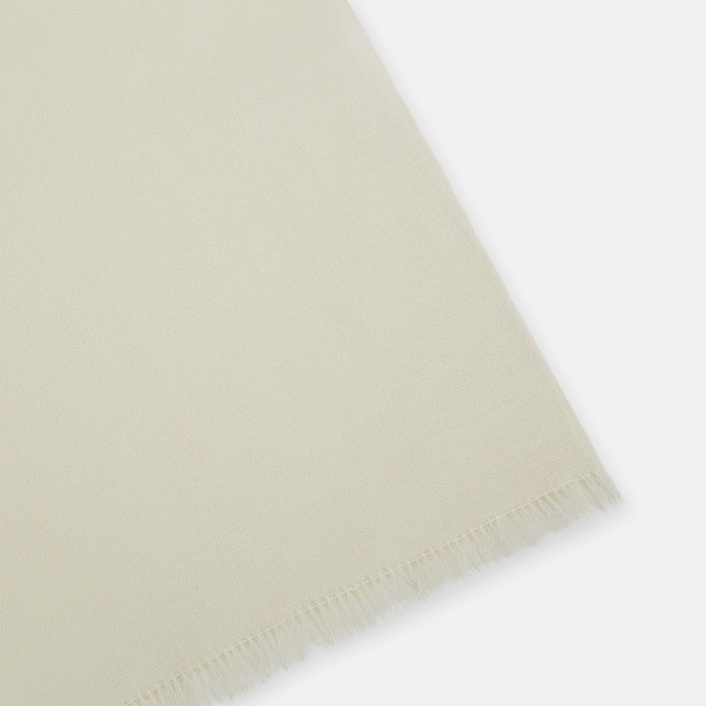 The Turnbull & Asser White Cashmere Scarf features a soft, cream-colored lightweight texture and fringed edges, elegantly displayed on a white background—ideal for adding sophistication to eveningwear.