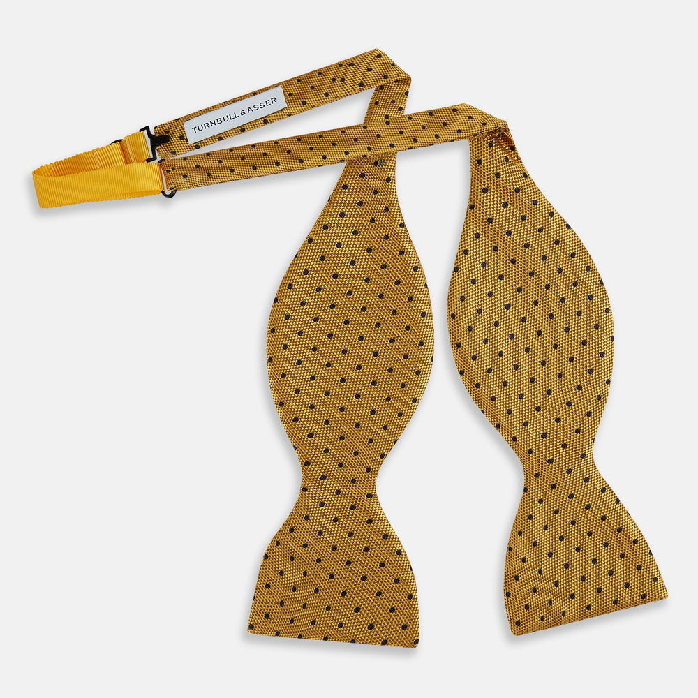 The Navy and Yellow Micro Dot Silk Bow Tie by Turnbull & Asser features a refined dot pattern—an ideal accessory for elevating sophisticated outfits.