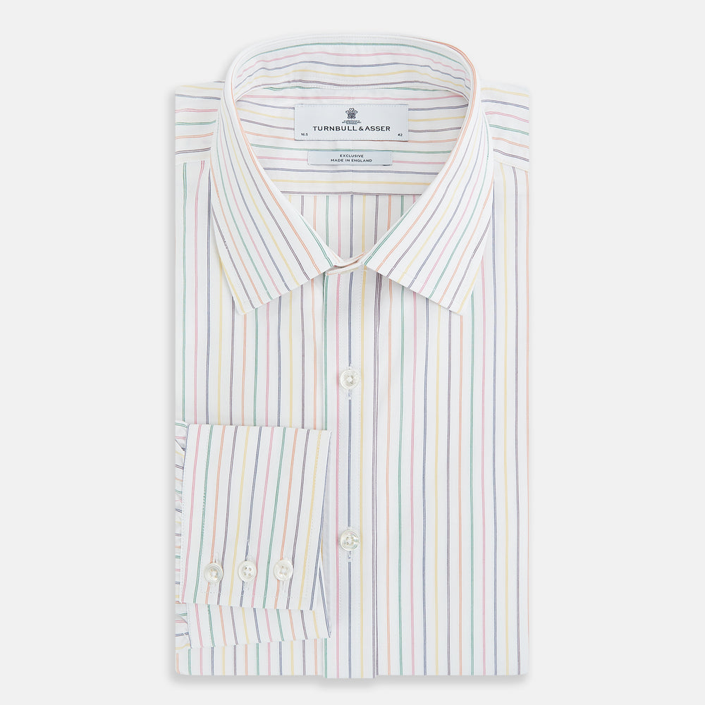 The Turnbull & Asser Rainbow Double Pinstripe Mayfair Shirt is a pure cotton, long-sleeved button-up with a collar and buttoned cuffs, featuring colourful blue, red, and yellow stripes on white, displayed on a plain white background.
