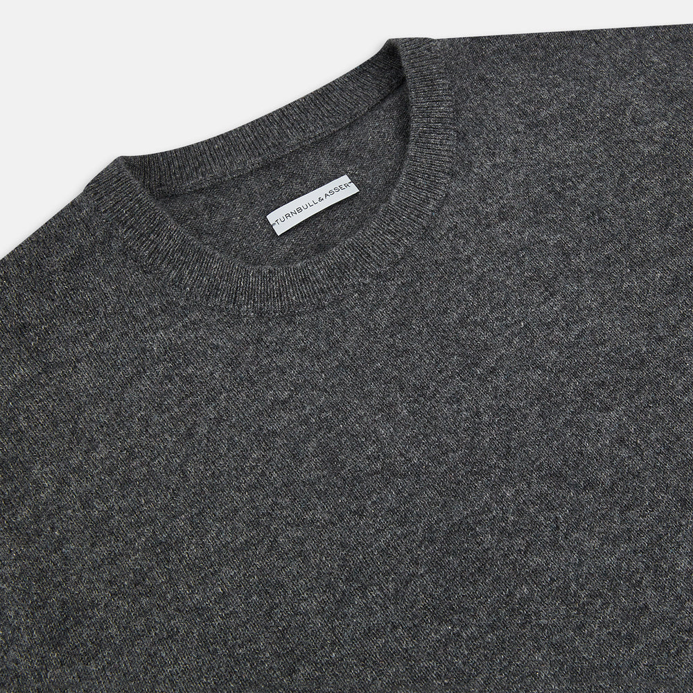 The Turnbull & Asser Charcoal Grey Cashmere Round Neck Jumper features a crew neck, long sleeves, and ribbed cuffs, collar, and hem—an essential piece of men’s knitwear displayed on a white background.