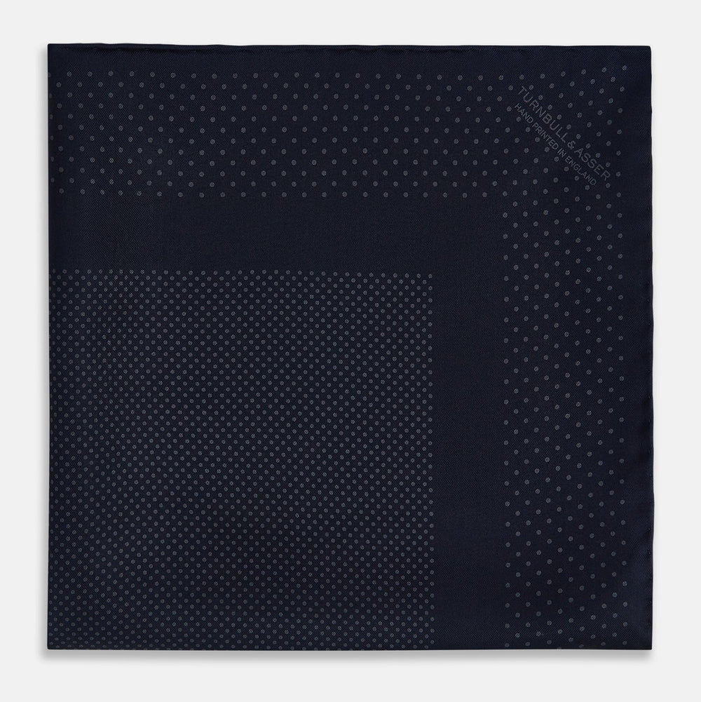The Turnbull & Asser Navy and Charcoal Dot Silk Pocket Square features a subtle dotted pattern and a folded corner, shown on a white background.