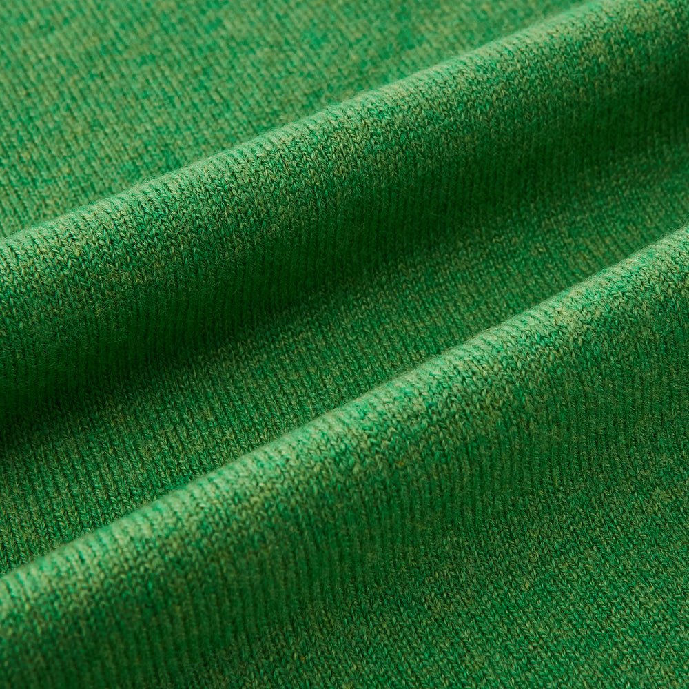 The Turnbull & Asser Plain Kelly Green Cashmere Knitted Scarf is shown looped at the top with both ends hanging down, its soft texture and vibrant color standing out against a plain white background.