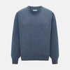 View 1 of product The Turnbull & Asser Pacific Blue Cashmere Round Neck Jumper features long sleeves and ribbed cuffs, hem, and neckline, shown on a light grey background.