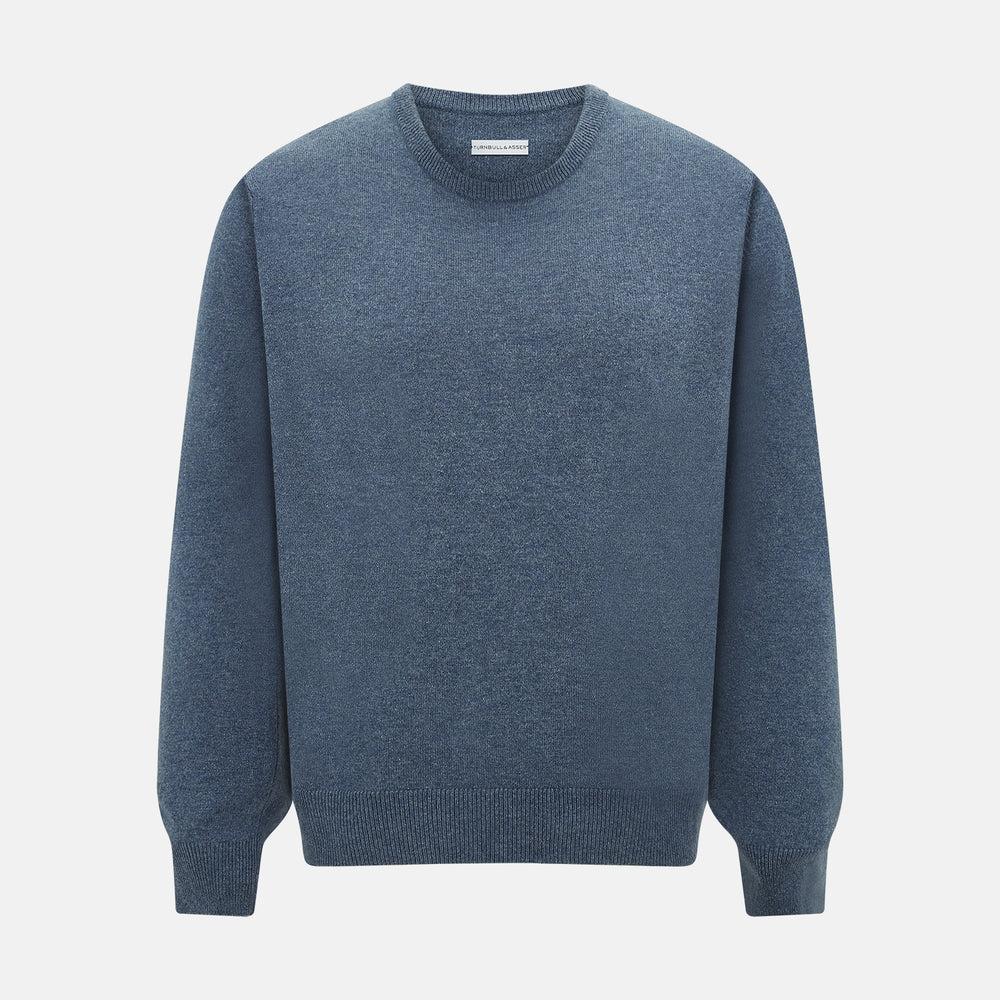 The Turnbull & Asser Pacific Blue Cashmere Round Neck Jumper features long sleeves and ribbed cuffs, hem, and neckline, shown on a light grey background.