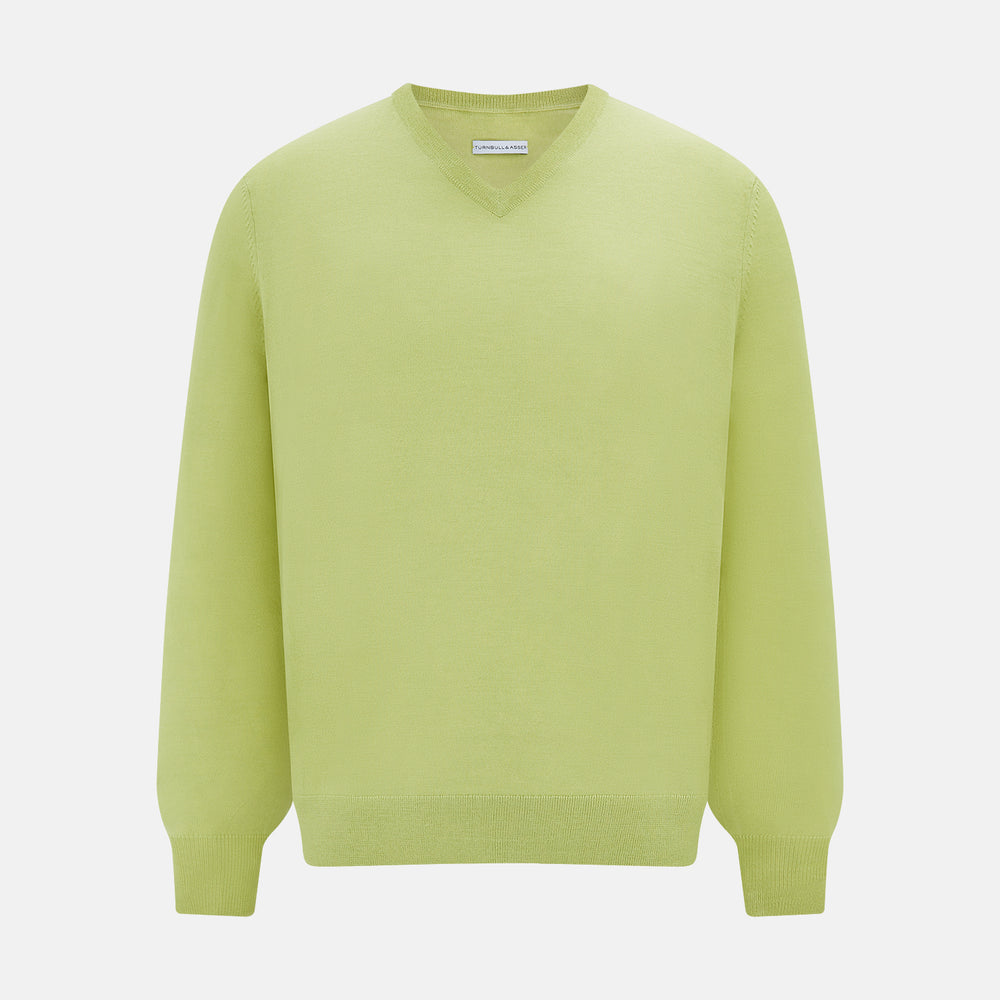 The Turnbull & Asser Melon Green Merino V-Neck Jumper is shown on a white background, featuring long sleeves, ribbed cuffs, and a ribbed hem.