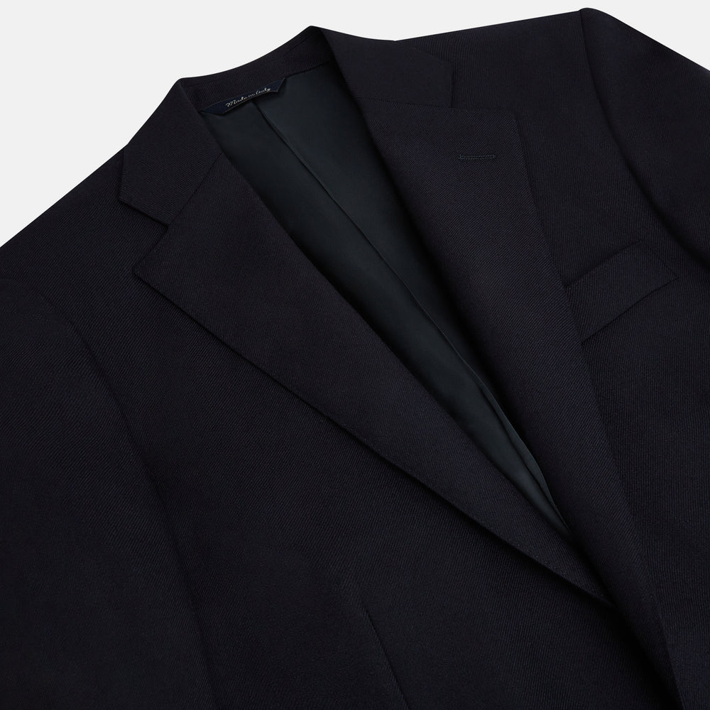 The Short Navy Single Breasted Classic Blazer by Turnbull & Asser features two gold buttons, notched lapels, and three front pockets, shown here on a plain white background.