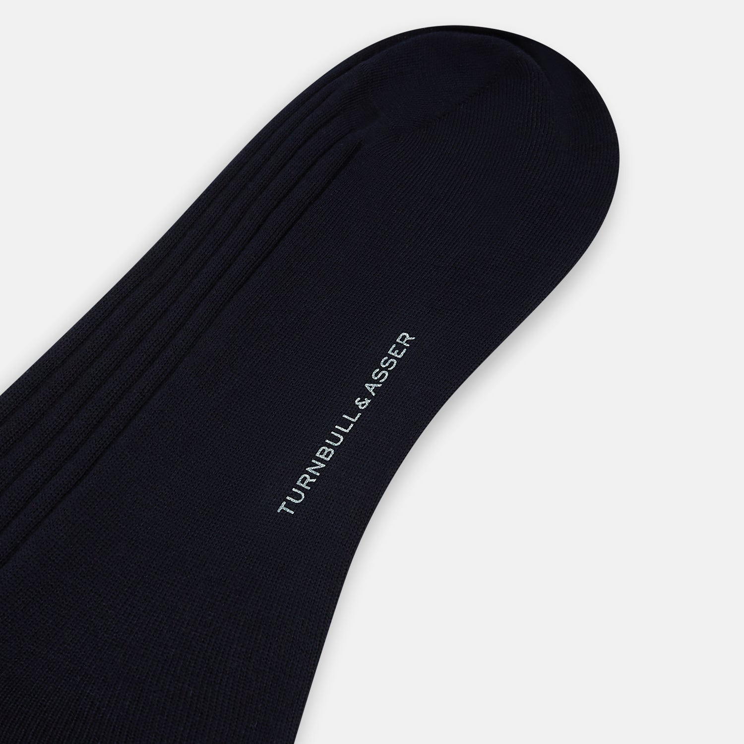 View 3 of product A single navy mid-length sock by Turnbull & Asser, crafted from organic cotton with a ribbed texture, stands upright on a white background.