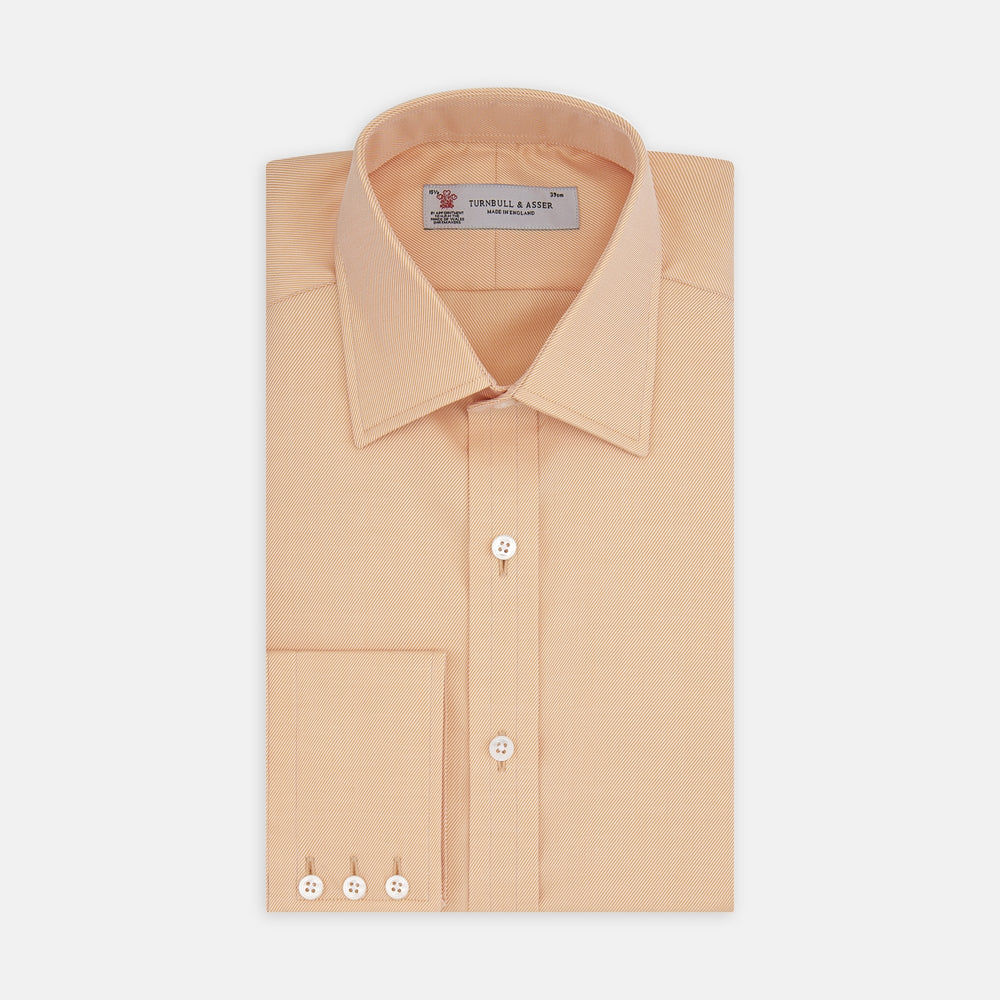 A neatly folded Orange Oxford Classic Fit Shirt with a T & A collar by Turnbull & Asser is displayed on a white background—a versatile piece for minimalist outfits or pairing with bold ties.